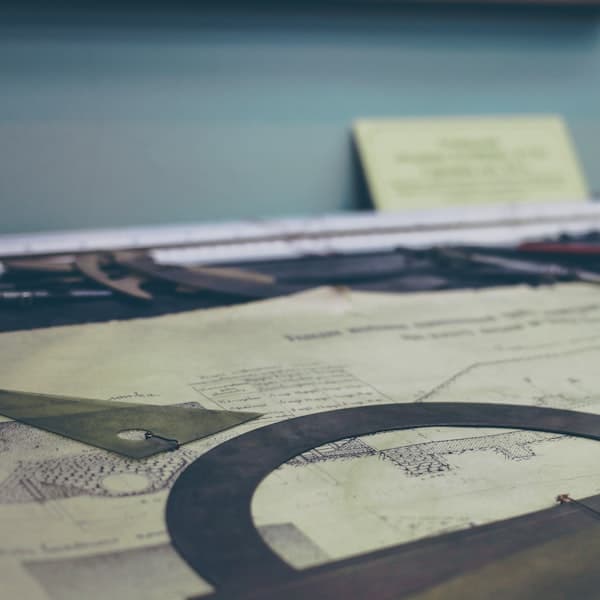 Engineering drawings and measuring tools on a bench