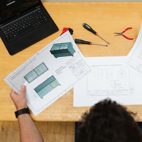 Engineering drawings and measuring tools on a bench