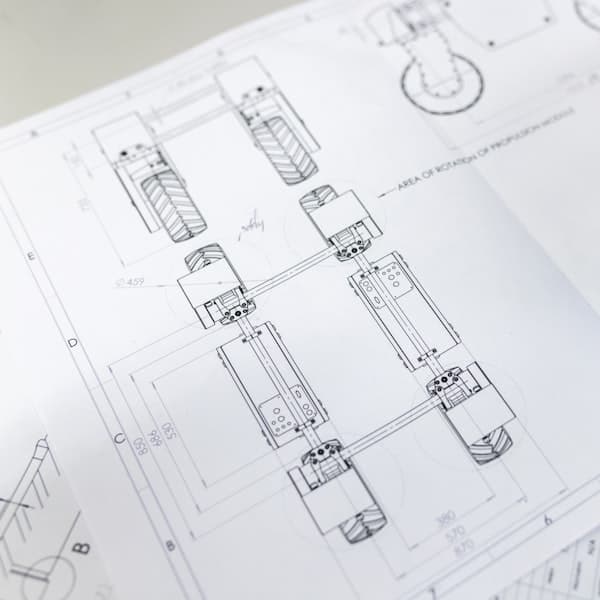Engineering drawings and measuring tools on a bench