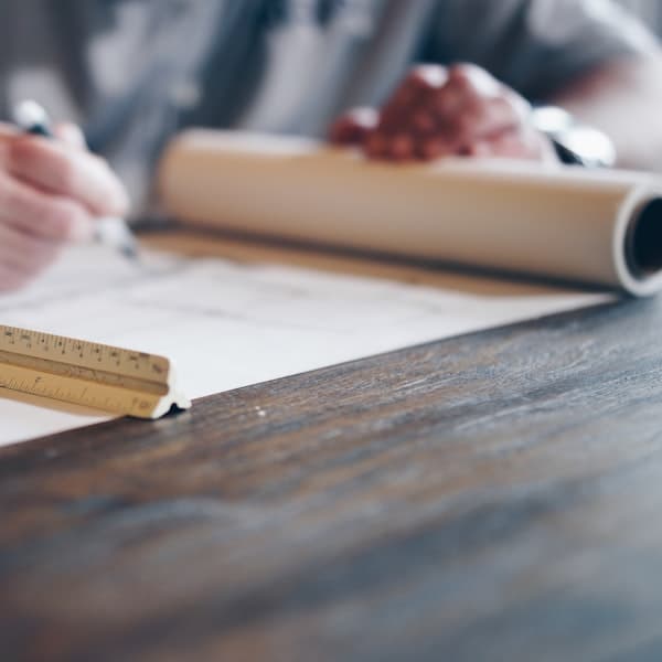 Engineering drawings and measuring tools on a bench