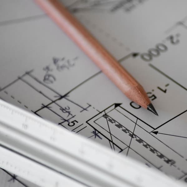 Engineering drawings and measuring tools on a bench